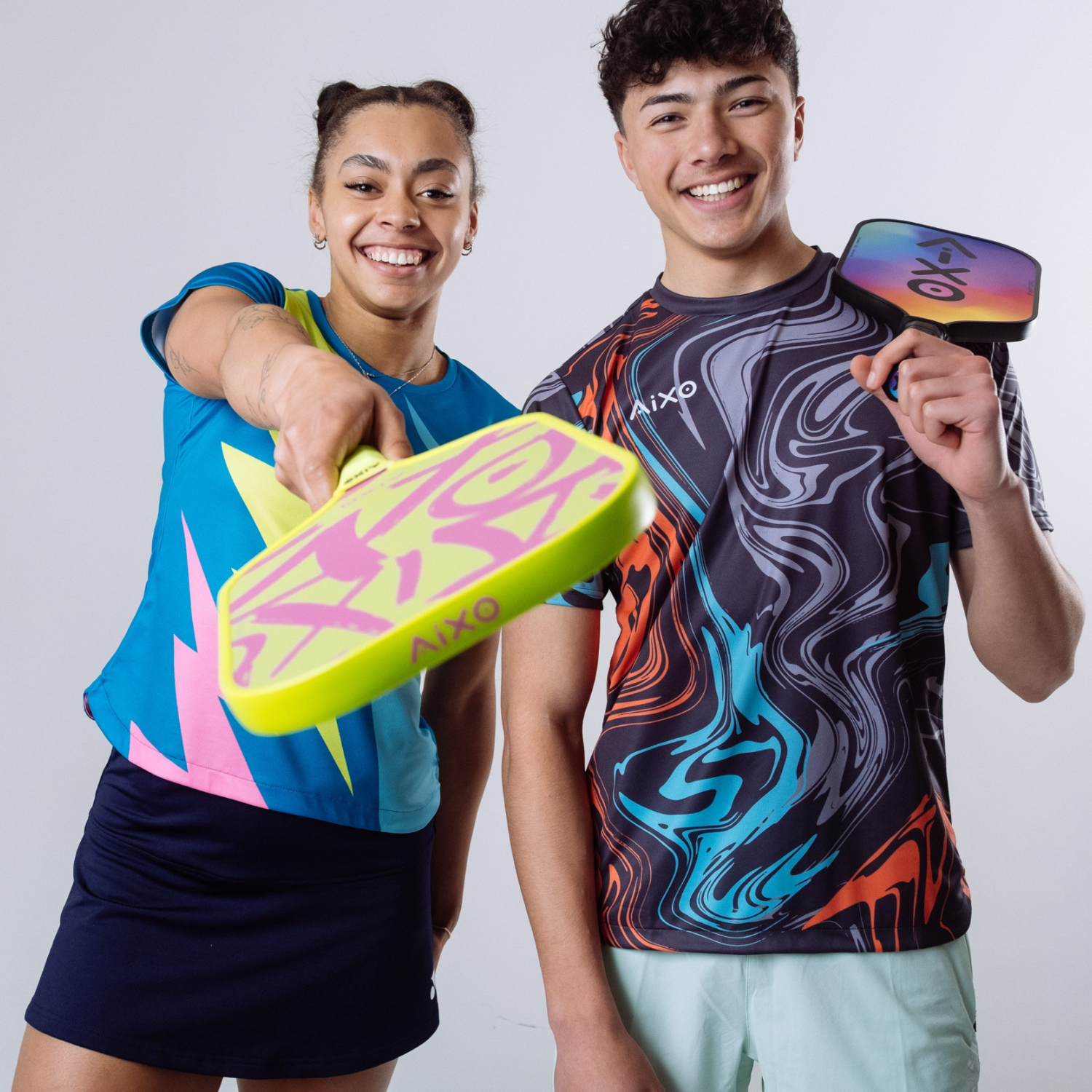 Couple with AIXO Ghost Neotag paddles — neon design meets street-inspired confidence on court.